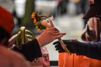 Mulher recebe flores e mantimentos durante ação social no Harlem, em Nova York, para o Dia das Mães.