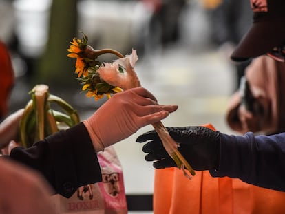 Mulher recebe flores e mantimentos durante ação social no Harlem, em Nova York, para o Dia das Mães.