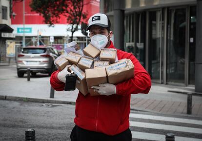 Un repartidor de Correos Express se prepara para entregar varios paquetes, en una calle del centro de Madrid. 