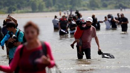 Una hilera de inmigrantes centroamericanos cruza la frontera entre Guatemala y México a través del río Suchiate.
