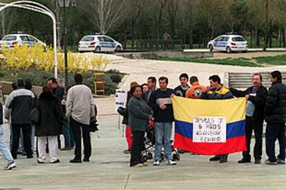 Unos comerciantes colombianos muestran una bandera de su país con una pancarta en protesta por la orden del Ayuntamiento de desmantelar su mercadillo.