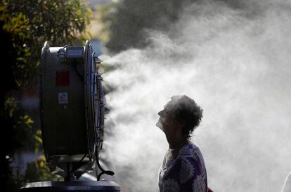 Una mujer se refresca delante de un ventilador brumizador durante el primer día del Abierto de Australia, que se disputa en Melbourne.