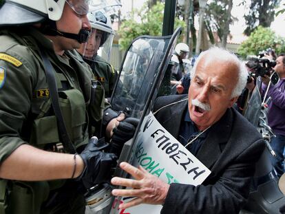 Un pensionista intenta romper la barrera de seguridad durante la protesta ayer en Atenas (Grecia) contra las medidas de ajuste.
