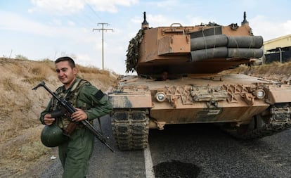 Un soldado turco asegura una carretera antes de que un tanque del Ejército avance hacia la frontera turco-siria, en Ceylanpinar.