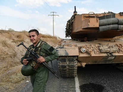 Un soldado turco asegura una carretera antes de que un tanque del Ejército avance hacia la frontera turco-siria, en Ceylanpinar.