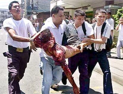 Varias personas transportan a uno de los heridos en el atentado de ayer en Filipinas.