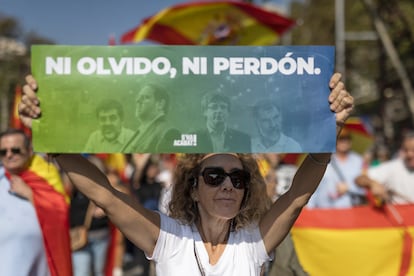 Una manifestante sostiene un cartel con el lema 'Ni olvido, ni perdón', este domingo en Barcelona. 