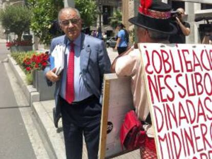 El consejero de Novacaixagalicia José Costas, ante un manifestante de las participaciones preferentes, a su salida el 28 de junio del consejo de administración de la entidad.