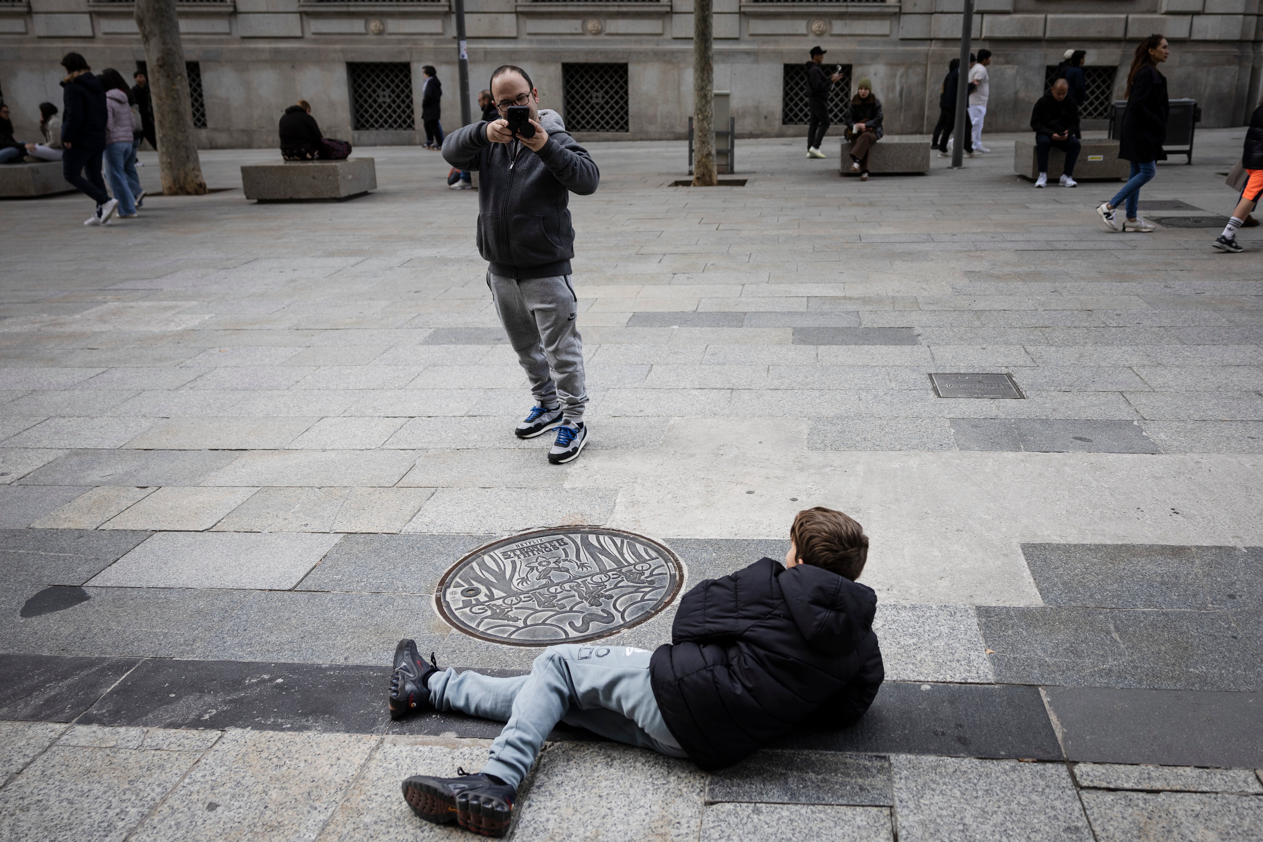 Seguidores fotografiándose junto a una tapa de la serie Stranger Things en Barcelona