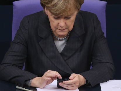No parece un iPhone, pero bueno: es Angela Merkel y est&aacute; cacharreando con un m&oacute;vil,