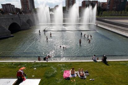 Decenas de bañistas se refrescan en las fuentes monumentales del proyecto Madrid Río junto al Puente de Segovia.