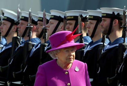 La reina Isabel II de Inglaterra inspecciona la guardia de honor durante la visita que ha realizado al buque portahelic&oacute;pteros HMS Ocean en la base naval de Devonport, al suroeste de Inglaterra. 