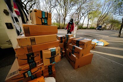 Un hombre mira paquetes entregados por Amazon durante la cuarentena.