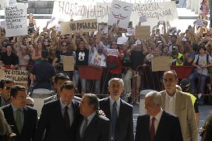 Integrantes del movimiento 15-M increpan a Rajoy a su llegada al Ayuntamiento de Sevilla para la toma de posesión de Juan Ignacio Zoido como alcalde.