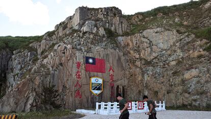 Soldiers march past a sign of the Taiwan flag on Dongyin island of Matsu archipelago in Taiwan August 15, 2022. REUTERS/Ann Wang