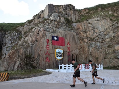 Soldiers march past a sign of the Taiwan flag on Dongyin island of Matsu archipelago in Taiwan August 15, 2022. REUTERS/Ann Wang