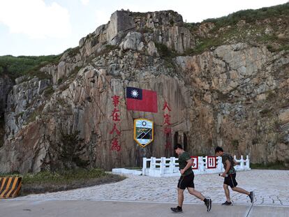 Soldiers march past a sign of the Taiwan flag on Dongyin island of Matsu archipelago in Taiwan August 15, 2022. REUTERS/Ann Wang