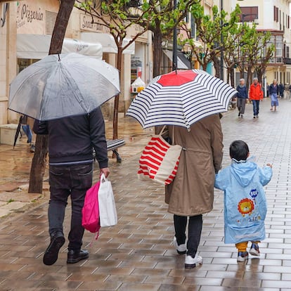 MAHÓN (MENORCA), 14/04/2025.- Una familia se protege de la lluvia con paraguas este lunes en el centro histórico de Mahón, Menorca. EFE/David Arquimbau Sintes
