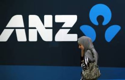 Una mujer camina junto al logotipo del banco australiano y neozelandés ANZ en su sede en Sídney (Australia). EFE/Archivo