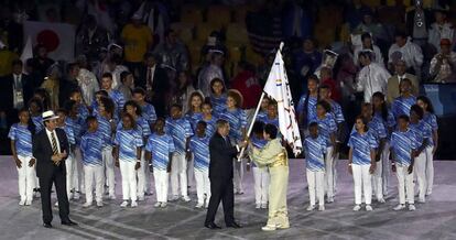 O governador de Tóquio, Yuriko Koike, recebe a bandeira dos Jogos Olímpicos de Thomas Bach, Presidente do Comitê Olímpico Internacional (COI), observados por Eduardo Paes, o prefeito do Rio de Janeiro.