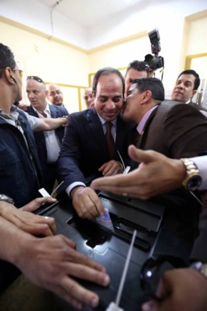 Un hombre besa al candidato Al Sisi mientras éste deposita el voto en la urna ayer en El Cairo.