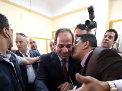 Un hombre besa al candidato Al Sisi mientras éste deposita el voto en la urna ayer en El Cairo.