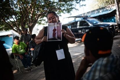 Rosa Elisabet Flores, de Honduras, muestra el retrato de su hijo Selvin René Hernandez Flores, desaparecido en transito por México, a los migrantes del albergue Hermanos en el canimo de Ixtepec, en Oaxaca.