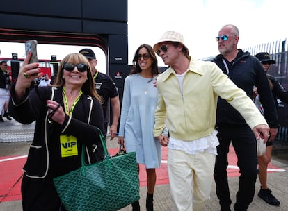 Brad Pitt, acompañado de Inés de Ramón, se toma una foto con una aficionada en el circuito de Silverstone, durante el Gran Premio de Fórmula 1 de Gran Bretaña, en Northampton, el 7 de julio de 2024.