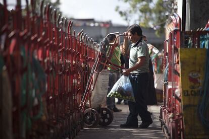 Un hombre lleva un 'diablito', un carrito para mover la mercancía, en la Central de Abastos de la capital mexicana.