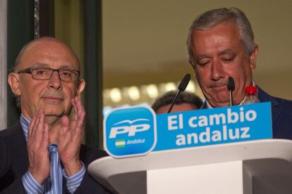 Javier Arenas y Cristóbal Montoro, en el balcón de la sede del PP en Sevilla, tras darse a conocer la victoria de su formación en Andalucía sin mayoría absoluta.