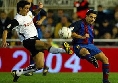 El valencianista Vicente y el jugador del F.C. Barcelona Xavi, en un partido disputado el pasado sábado.