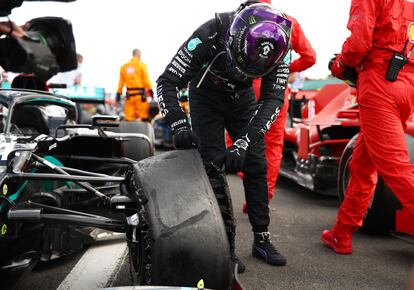 Lewis Hamilton, tras la carrera, observa la rueda de su coche destrozada.