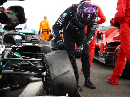 Lewis Hamilton, tras la carrera, observa la rueda de su coche destrozada.
