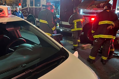 Bomberos de San Francisco durante el rescate de una víctima del incidente que involucró a un coche autónomo de Cruise, de GM.