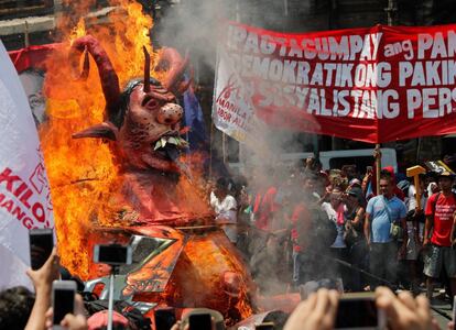 Vários ativistas queimam uma boneca que representa o presidente filipino, Rodrigo Duterte, durante uma manifestação pelo Dia Internacional do Trabalho, em Manila (Filipinas).