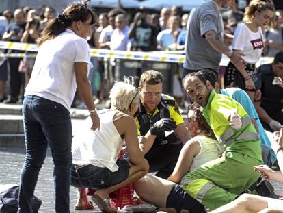 Agentes de polic&iacute;a y un trabajador atienden a los heridos en el atentado terrorista de La Rambla.
 
 