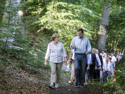 El presidente del Gobierno, Mariano Rajoy, y la canciller alemana, Angela Merkel, recorren un tramo del Camino de Santiago, en 2014.