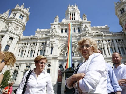 La alcaldesa de Madrid, Manuela Carmena, asiste al despliegue de la bandera arco iris en la fachada del Palacio de Cibeles.