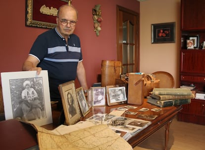 Alfonso Sanza, in the living room of his house, next to family photographs and objects inherited from Byne, including a suitcase, maps and history books.