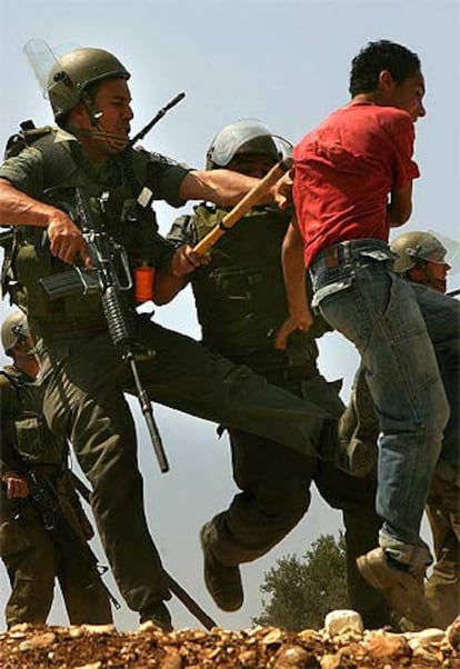 Un manifestante palestino es golpeado por dos soldados israelíes ayer cerca de Ramala.
