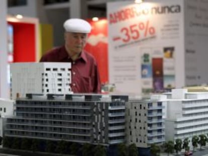 Un visitante observa una maqueta en un stand en un salón inmobiliario. EFE/Archivo