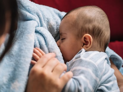 Una mujer dando de mamar a su bebé.