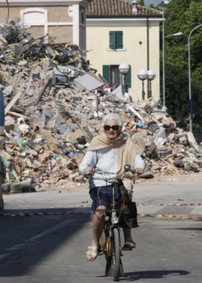 Una mujer pedalea por Cavezzo tras el terremoto.