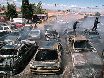 Los bomberos extinguen las llamas del desguace en el que quedaron calcinados 70 coches abandonados.