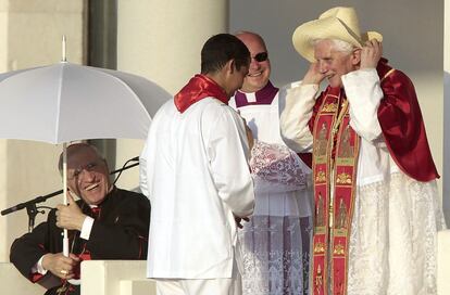 Benedicto XVI se ajusta un sombrero, ante la atenta mirada del cardenal Rouco Varela, en el transcurso de un acto de la Jornada Mundial de la Juventud, celebrada en Madrid en agosto de 2011