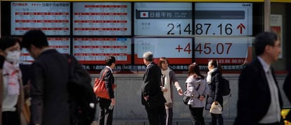 Viandantes frente a una casa de valores en Tokio (Japón)