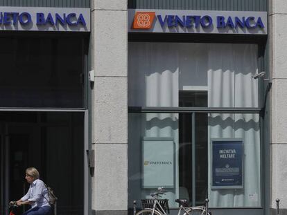 Una mujer pasa delante de una oficina de Veneto Banca en Mil&aacute;n