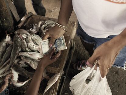 Un cliente paga por pescado en un mercado de alimentos en Riohacha, La Guajira, el 11 de agosto de 2022.