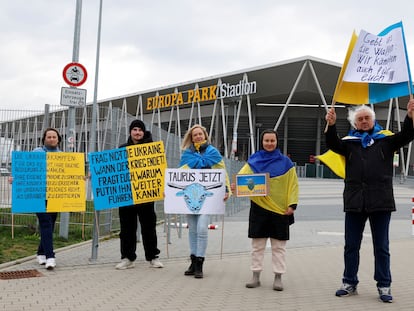 Pro-Ukrainian demonstrators hold signs, asking for Taurus cruise missiles to be delivered to Ukraine, outside football club SC Freiburg's Europa-Park Stadium as German Chancellor Olaf Scholz (not pictured) makes a visit in Freiburg, Germany, February 27, 2024.
