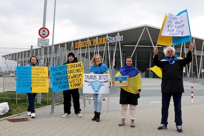 Pro-Ukrainian demonstrators hold signs, asking for Taurus cruise missiles to be delivered to Ukraine, outside football club SC Freiburg's Europa-Park Stadium as German Chancellor Olaf Scholz (not pictured) makes a visit in Freiburg, Germany, February 27, 2024.